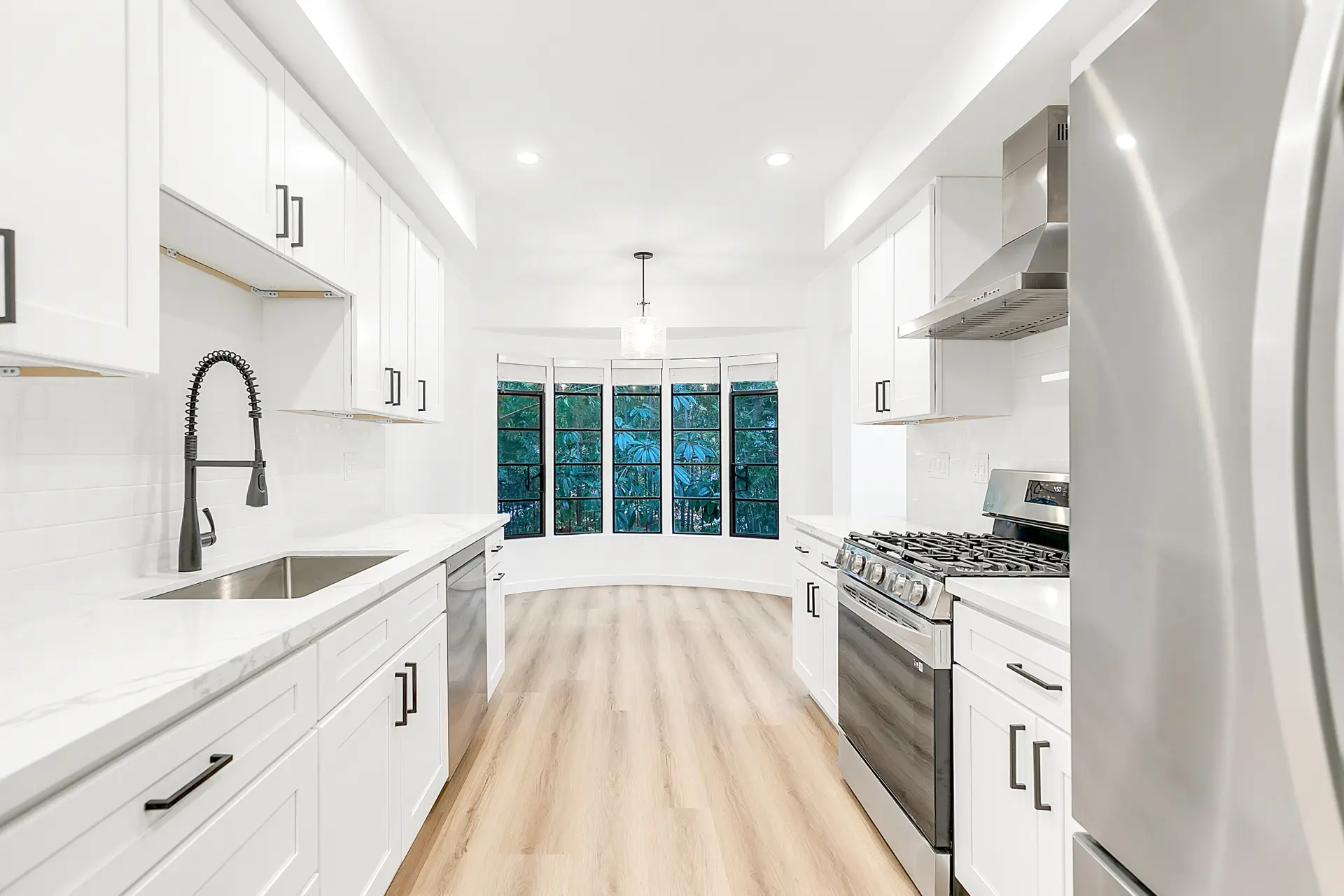 Renovated kitchen in Unit 1846 with white cabinetry and a bay window